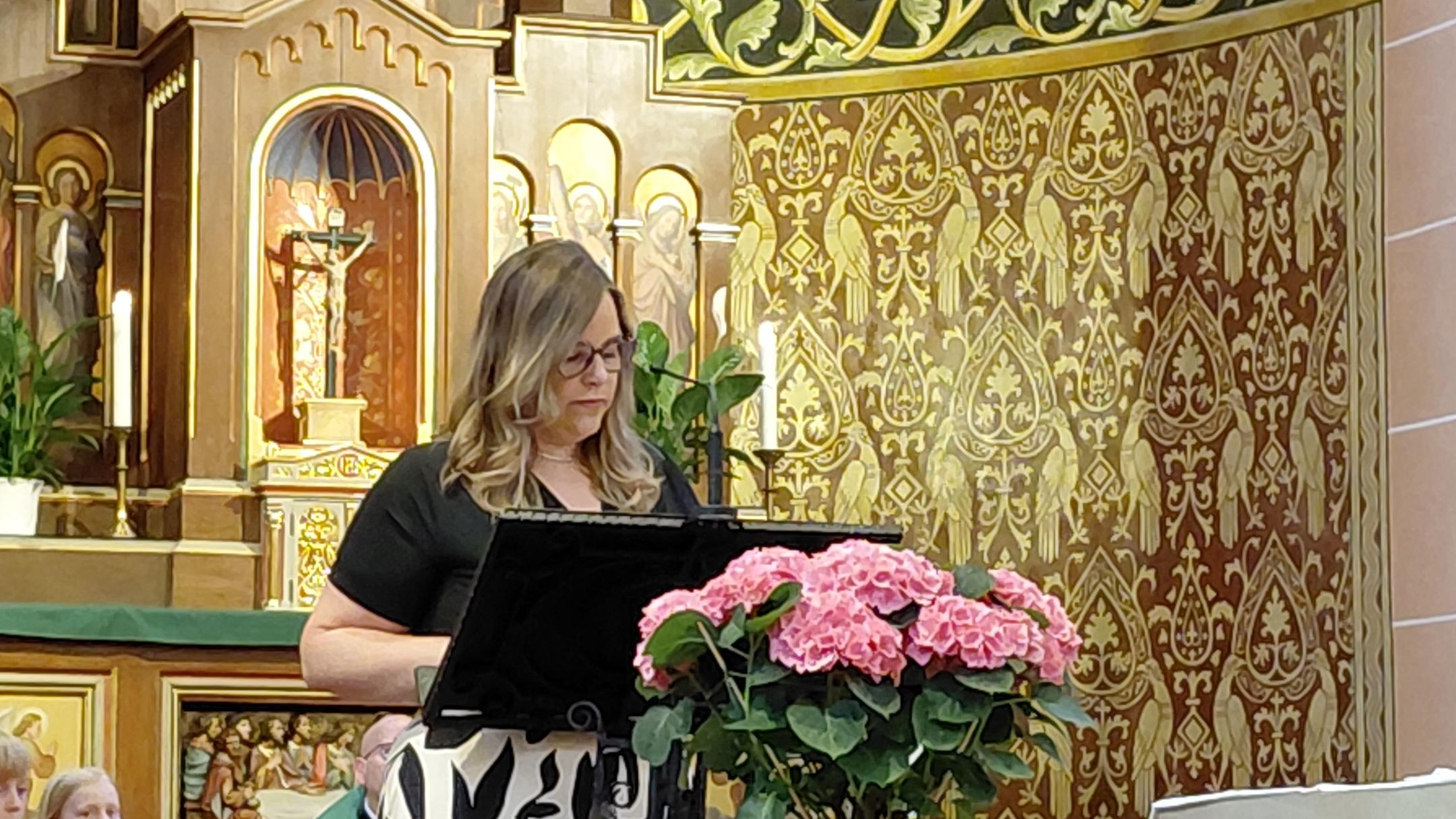 Frau Schneider steht am Ambo im Kirchenraum der Kirche in Dieblich